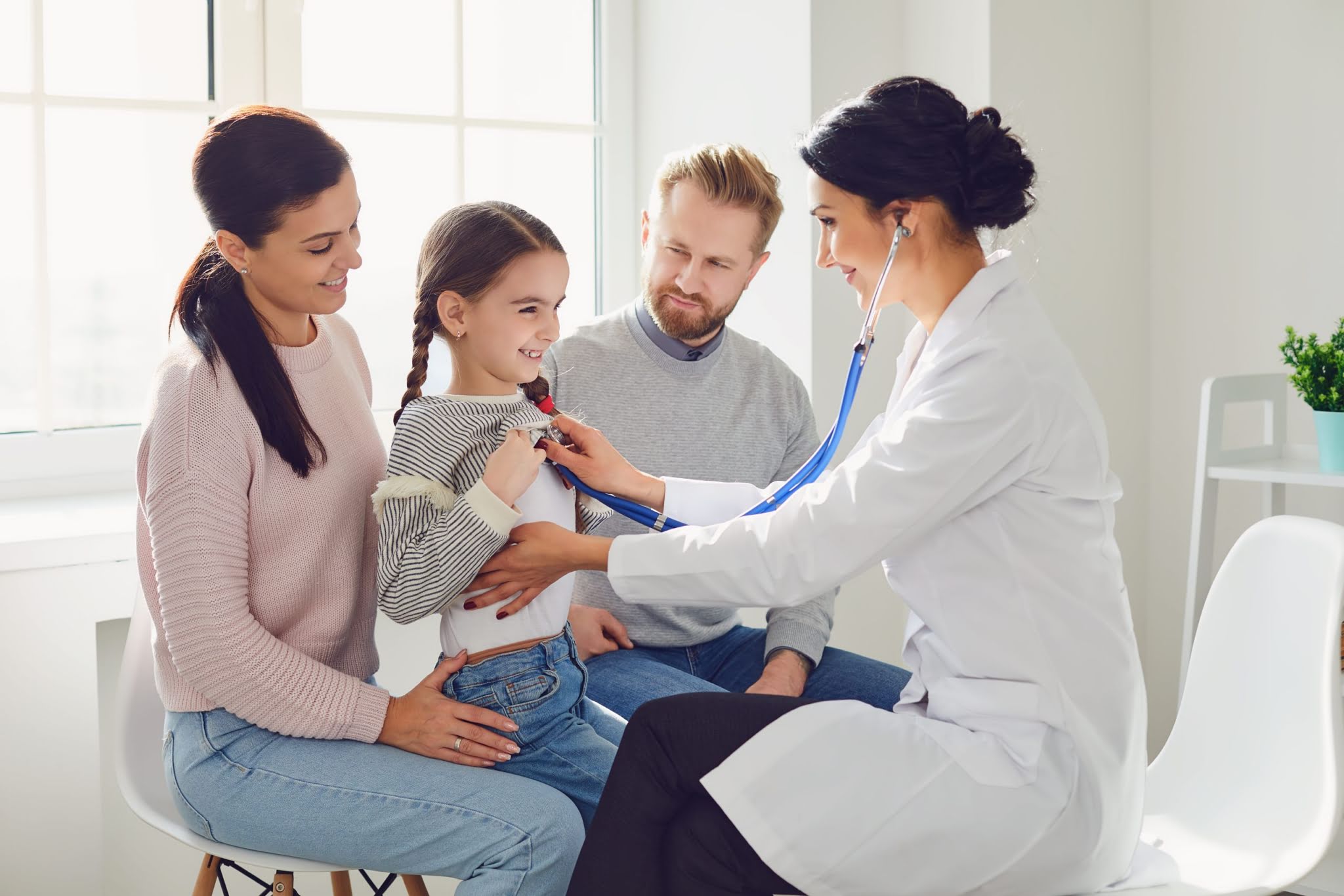 Happy family on a visit to the doctor in the office of a doctor.